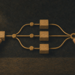 Hands arranging wooden blocks and brass connectors into a branching workflow on a dark textured surface